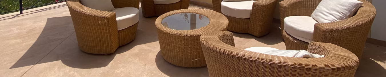 Outdoor seating area with rattan chairs, white cushions, glass table, and white parasol on terrace at Holiday Home Mallorca
